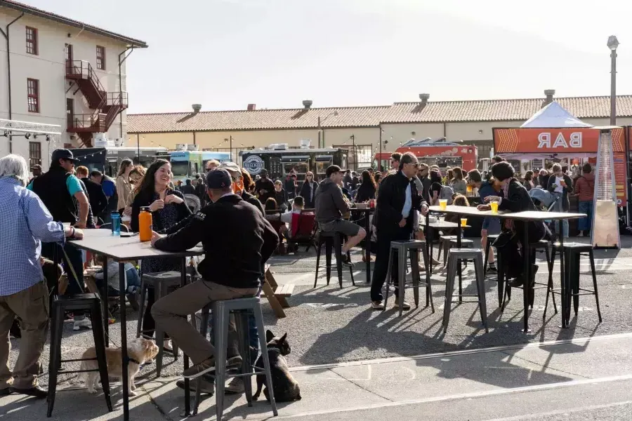 Une foule de gens se rassemblent pour manger dans des food trucks pendant Off the Grid au fort Mason Center.